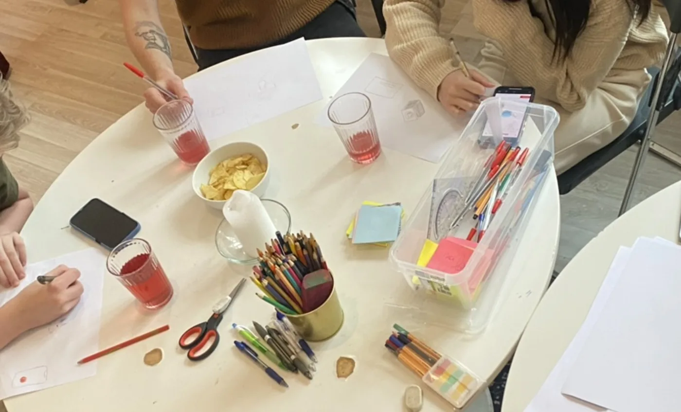 Skisser, fargeblyanter og post-it-lapper på workshopbordet